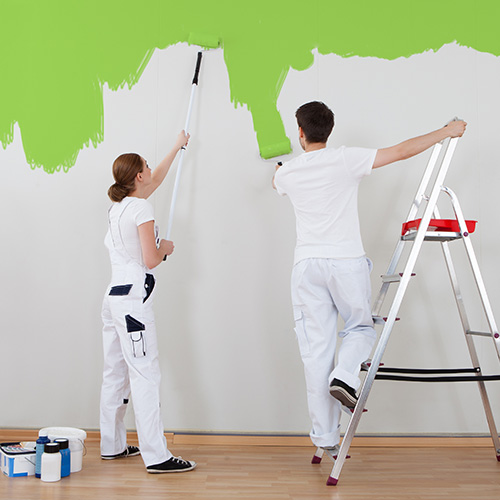 Deux techniciens qui peignent un mur, peinture verte
